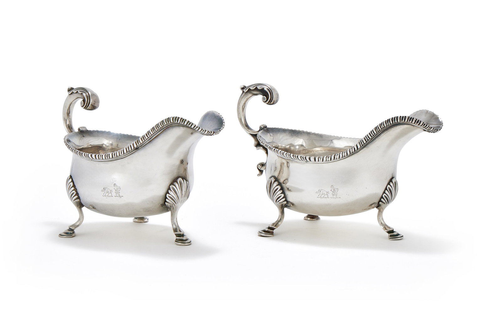 A PAIR OF GEORGE III SILVER OVAL SAUCE BOATS, GEORGE SMITH, LONDON 1766: A PAIR OF GEORGE III SILVER OVAL SAUCE BOATSGEORGE SMITH, LONDON 1766With leaf capped flying scroll handles, gadrooned borders, engraved with two crests and on three shell and stepped pad feet19cm lon