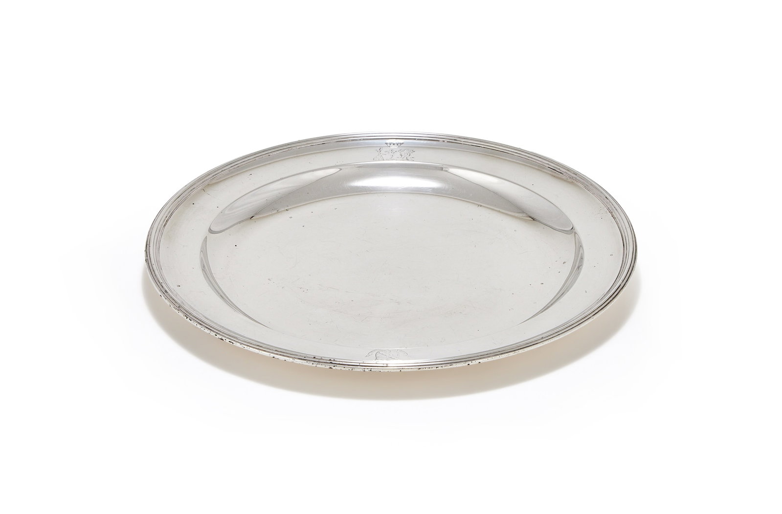 A GEORGE III SILVER CIRCULAR PLATE, ROBERT SHARP, LONDON 1796: A GEORGE III SILVER CIRCULAR PLATEROBERT SHARP, LONDON 1796With a reeded border, engraved with a coronet over three crests and an armorial25.5cm diameter538g (17.3 oz)These are the arms and separate c