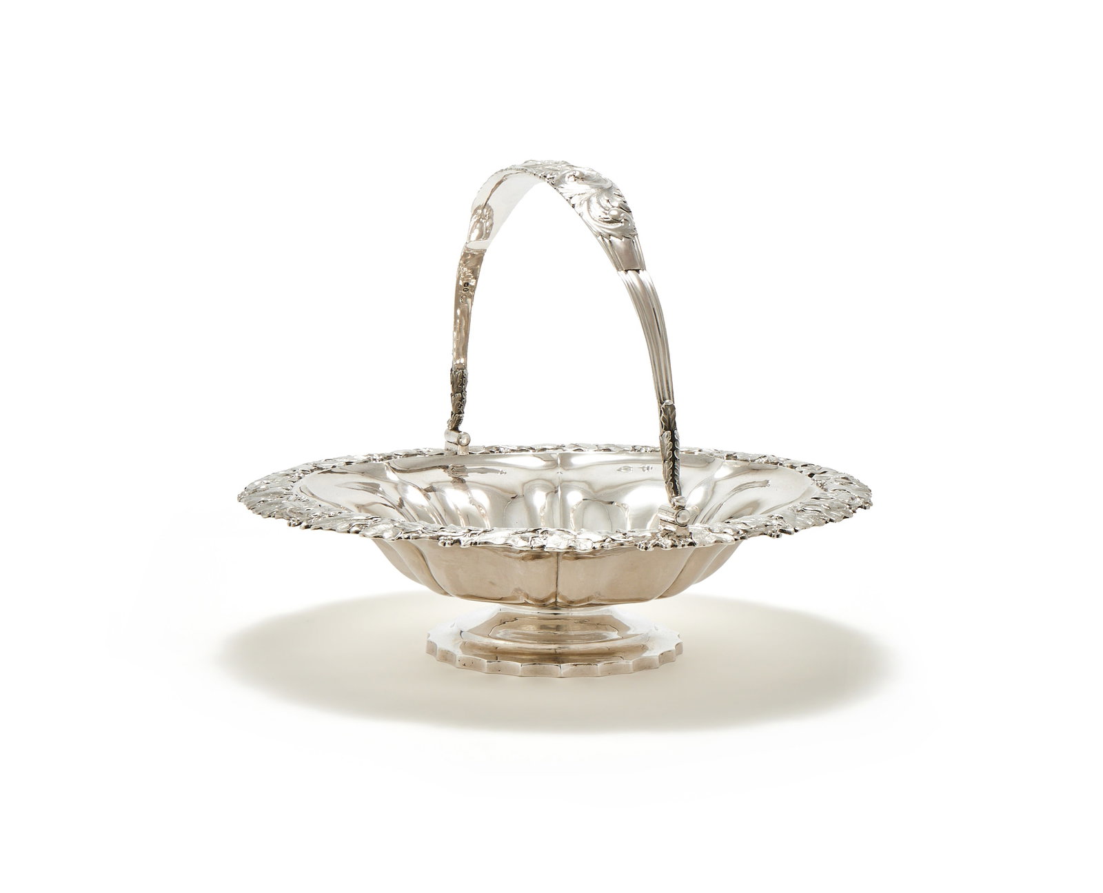 A GEORGE IV SILVER SHAPED CIRCULAR SWING HANDLED BASKET, CHARLES FOX II, LONDON 1829: A GEORGE IV SILVER SHAPED CIRCULAR SWING HANDLED BASKETCHARLES FOX II, LONDON 1829With a foliate chased swing loop handle, engraved 'ACE', a chased vine border and on a shaped circular pedestal foot33