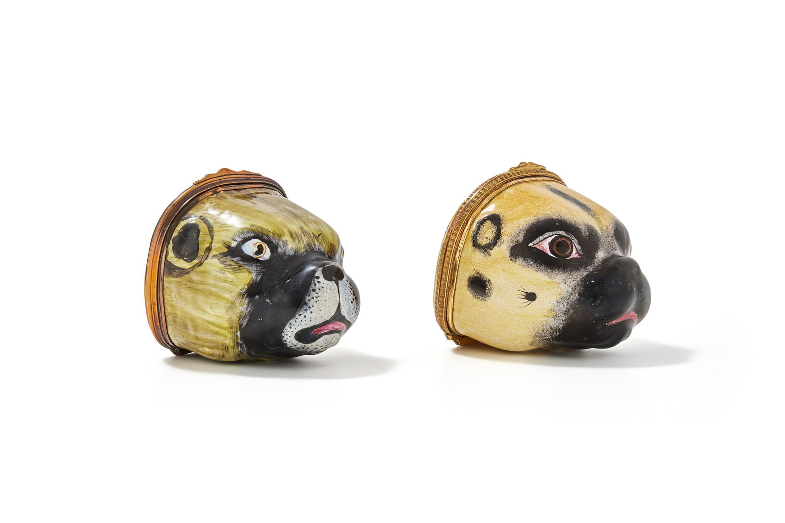 TWO ENAMEL PUG DOG SNUFF BOXES OR BONBONNIERS, LATE 18TH CENTURY: AN ENAMEL PUG DOG SNUFF BOX OR BONBONNIERPROBABLY SOUTH STAFFORDSHIRE OR GERMAN, LATE 18TH CENTURYModelled as the head of a pug, its coat sable and black, the lid painted with a dog in a park setting5