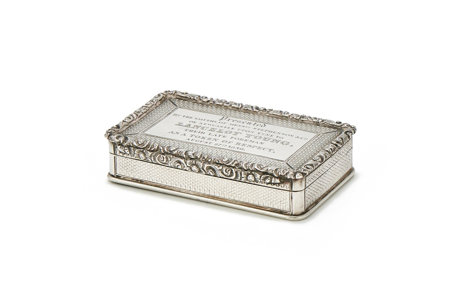 A WILLIAM IV SILVER SNUFF BOX, EDWARD SMITH, BIRMINGHAM 1835: A WILLIAM IV SILVER SNUFF BOXEDWARD SMITH, BIRMINGHAM 1835With engine turned decoration and a chased foliate border, the cover engraved 'Presented by the smiths of Mess. Stephenson & Co. of Newcastle 