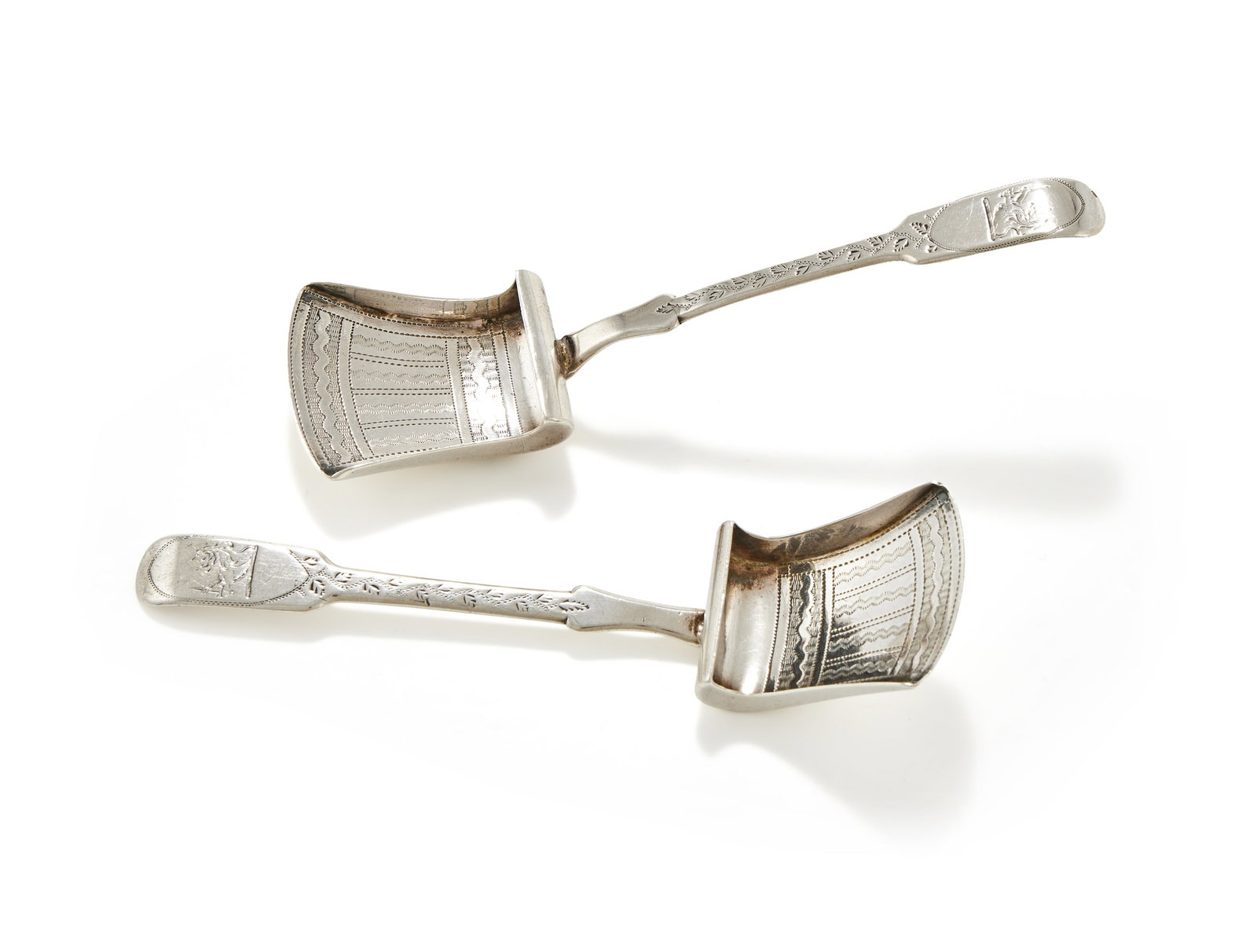 A PAIR OF GEORGE III SILVER FIDDLE PATTERN CADDY SOONS, WILLIAM PUGH, BIRMINGHAM 1811: A PAIR OF GEORGE III SILVER FIDDLE PATTERN CADDY SOONSWILLIAM PUGH, BIRMINGHAM 1811Engraved with a crest, foliage and wave decoration11.5cm long30g (0.95 oz)