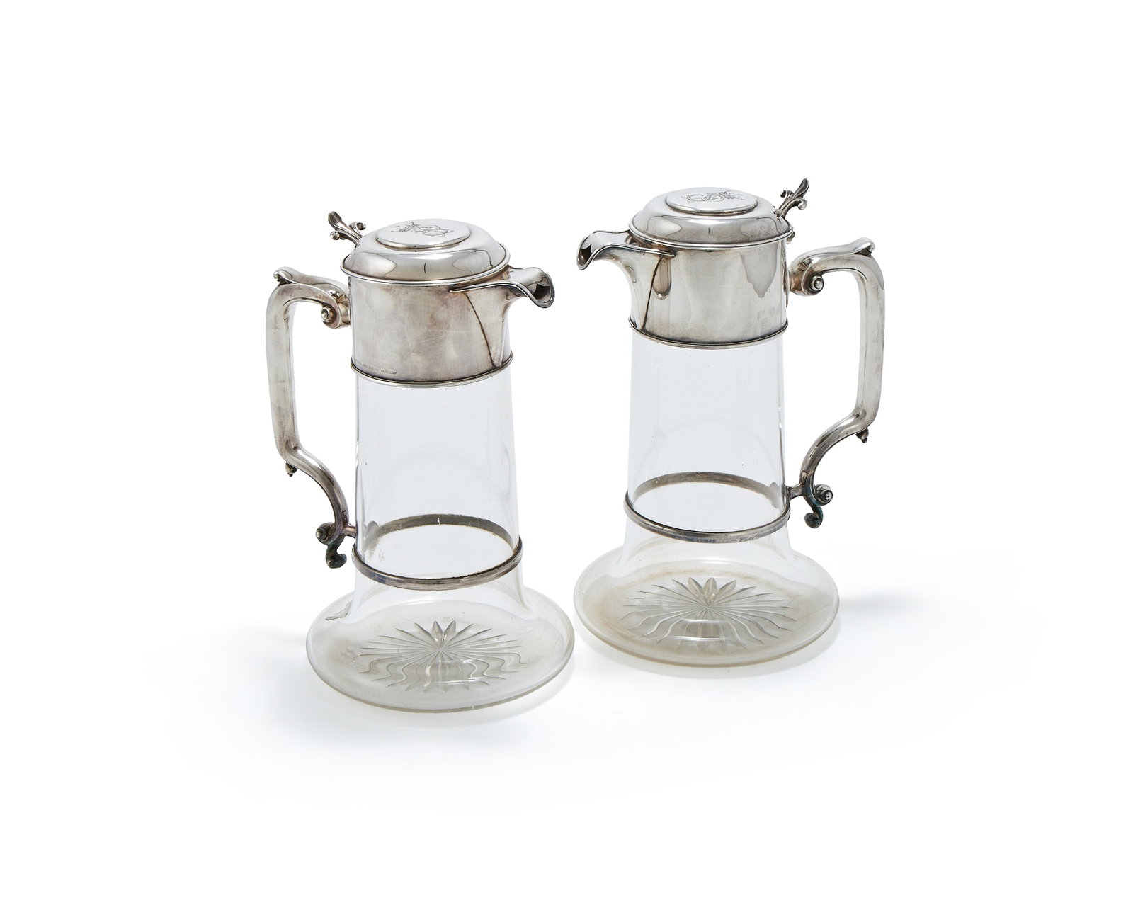 A CASED PAIR OF VICTORIAN SILVER MOUNTED AND GLASS CLARET JUGS, JAMES DIXON & SONS, SHEFFIELD 1885: A CASED PAIR OF VICTORIAN SILVER MOUNTED AND GLASS CLARET JUGSJAMES DIXON & SONS, SHEFFIELD 1885The covers engraved with Coronets over SP, scrolled thumb pieces and handles23.5cm high