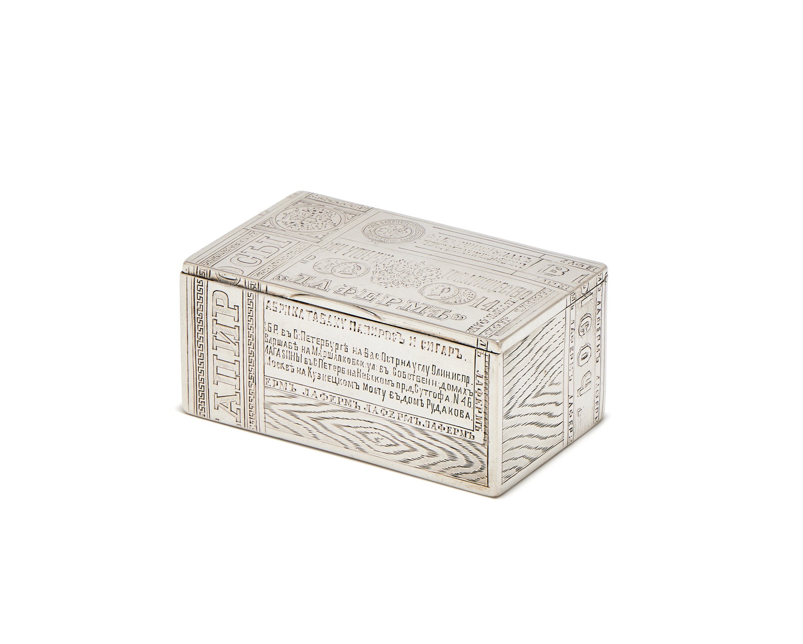A RUSSIAN SILVER TROMPE L'OEIL CIGAR BOX, MAKER'S MARK CYRILLIC A.L, ST PETERSBURG 1884: A RUSSIAN SILVER TROMPE L'OEIL CIGAR BOXMAKER'S MARK CYRILLIC A.L, ST PETERSBURG 1884Engraved to simulate a cigar box with wood grain, tax bands with Imperial Eagles and award medals9.5cm long183g (5.