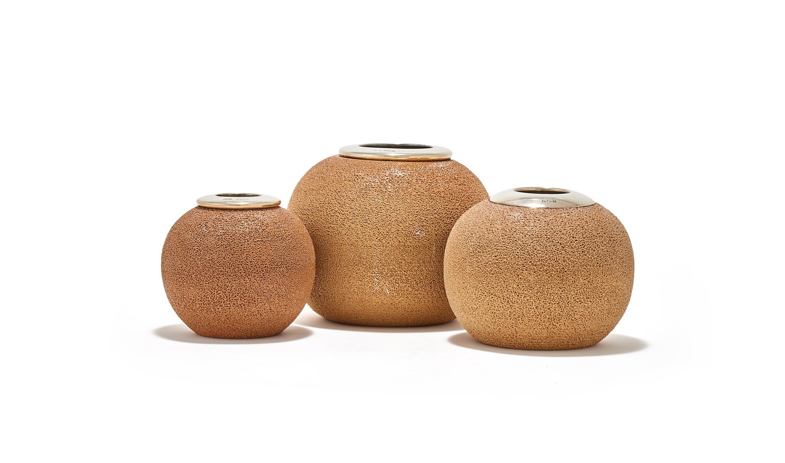 THREE ROYAL DOULTON POTTERY AND SILVER MOUNTED MATCH STRIKERS: THREEROYAL DOULTON POTTERY AND SILVER MOUNTED MATCH STRIKERSJOHN GRINSELL & SONS, BIRMINGHAM 1918 (1) AND 1924 (2), THE LARGEST STAMPEDFINNIGANSWith textured bodies and silver polished rims9cm, 11cm a