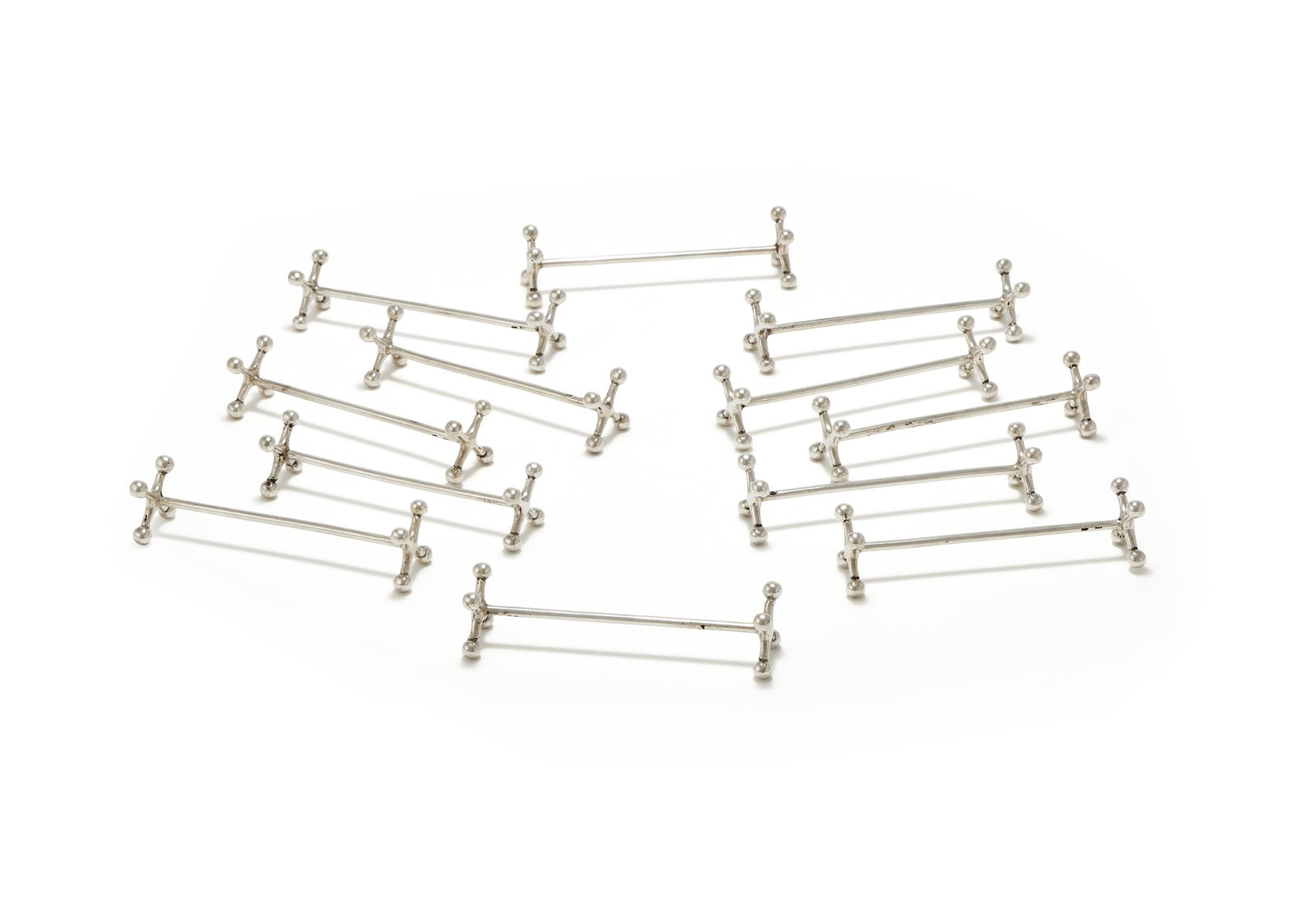 A SET OF TWELVE DUTCH SILVER KNIFE RESTS, BIJKAMP & CO., STEENWIJK, CIRCA 1960: A SET OF TWELVE DUTCH SILVER KNIFE RESTSBIJKAMP & CO., STEENWIJK, CIRCA 1960On ball and cross supports9.5cm long228g (7.3 oz)