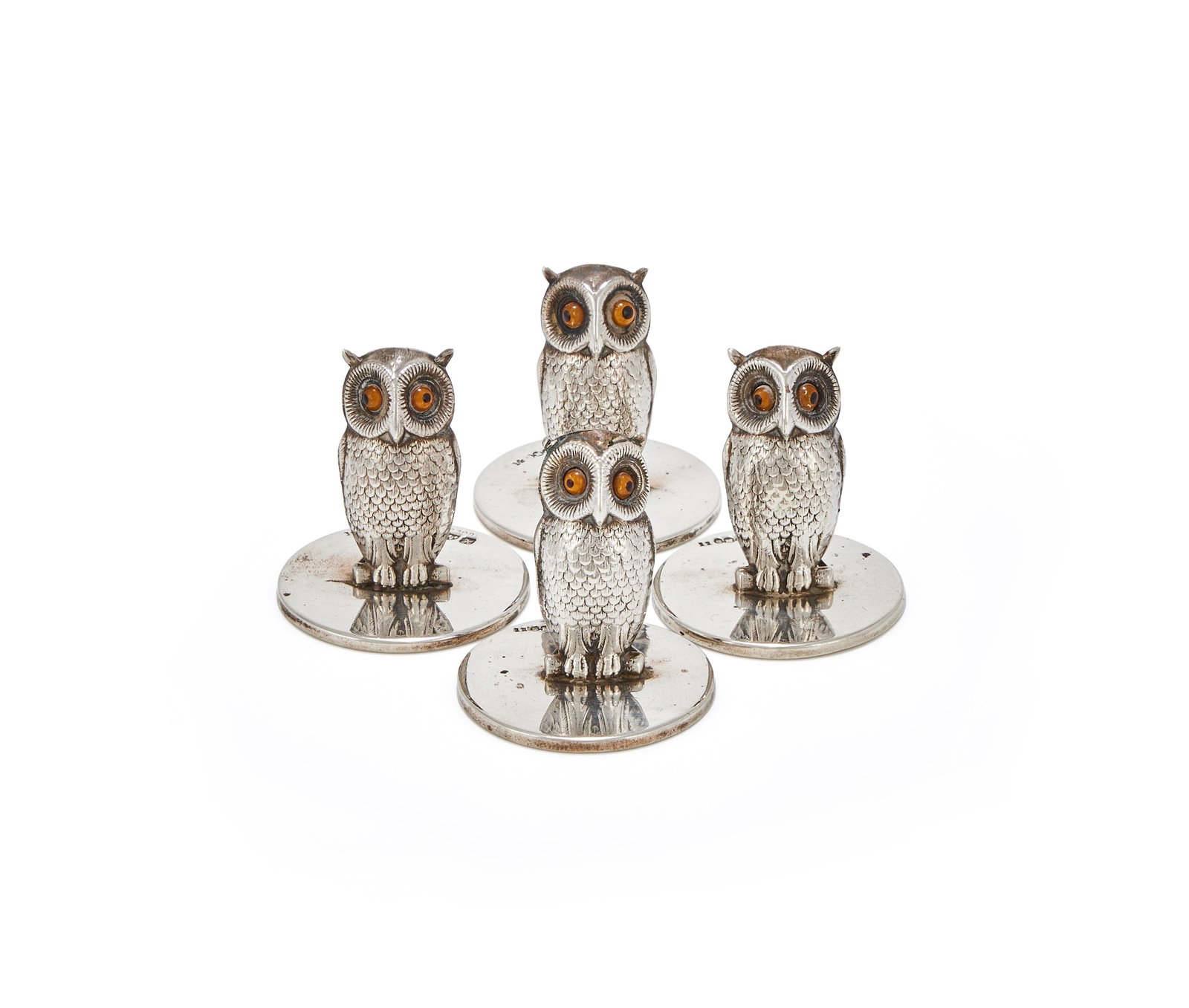 A CASED SET OF FOUR EDWARDIAN SILVER OWL MENU HOLDERS, SAMPSON MORDAN & CO.: A CASED SET OF FOUR EDWARDIAN SILVER OWL MENU HOLDERSSAMPSON MORDAN & CO., CHESTER 1907 (1) AND 1908 (3)With glass eyes and circular bases3.5cm diameter86g (2.8 oz) gross