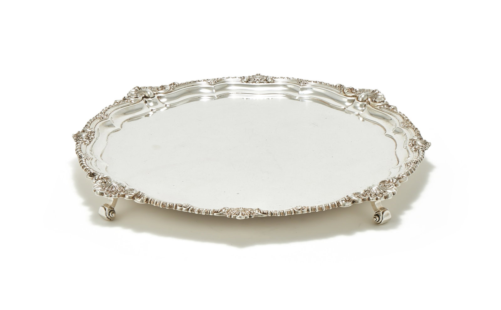 AN EDWARDIAN SILVER SHAPED CIRCULAR SALVER, HARRISON BROTHERS & HOWSON, LONDON 1905: AN EDWARDIAN SILVER SHAPED CIRCULAR SALVERHARRISON BROTHERS & HOWSON, LONDON 1905The gadrooned border with shells and foliage at intervals, on four scroll feet46cm diameter2188g (70.35 oz)