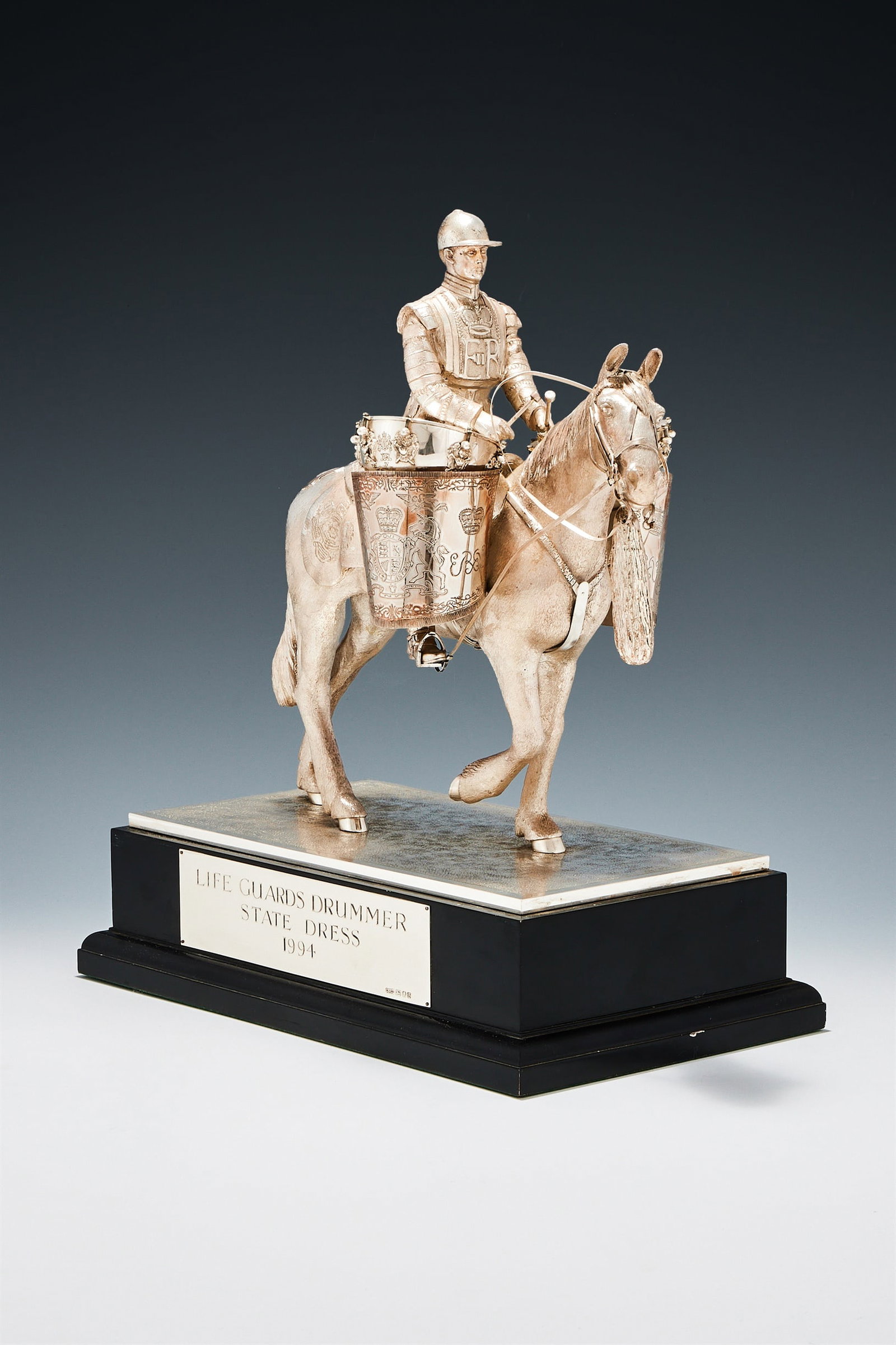 A SILVER FIGURE OF A LIFE GUARD EQUESTRIAN DUMMER IN STATE DRESS, CARRINGTON & CO., LONDON 1994: A SILVER FIGURE OF A LIFE GUARD EQUESTRIAN DUMMER IN STATE DRESSCARRINGTON & CO., LONDON 1994Mounted on horseback, on rectangular black plinth with a plaque inscribed 'Life Guards, Drummer State Dress