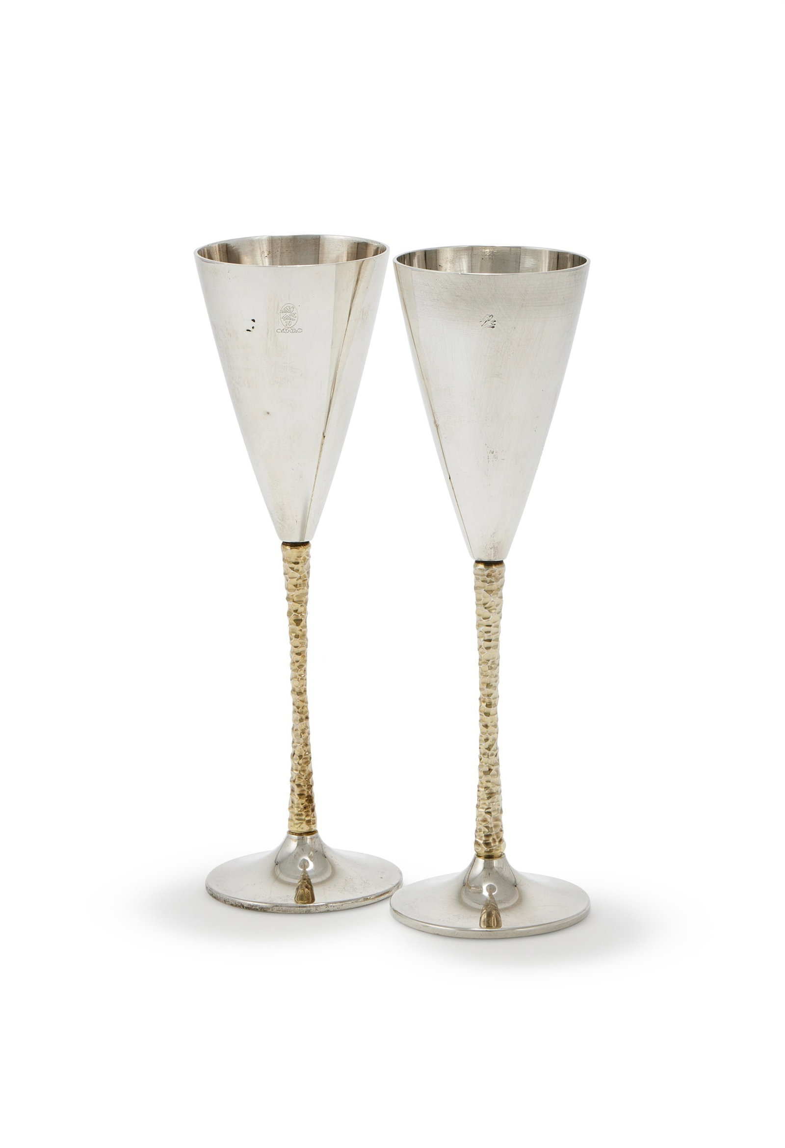 STUART DEVLIN, A PAIR OF SILVER AND SILVER GILT CHAMPAGNE FLUTES, LONDON 1978 AND 1980: STUART DEVLINA PAIR OF SILVER AND SILVER GILT CHAMPAGNE FLUTES, LONDON 1978 AND 1980With tapering bowls, silver gilt twig stems and on circular spreading bases22.5cm high401g (12.9 oz)Provenance:A Pri