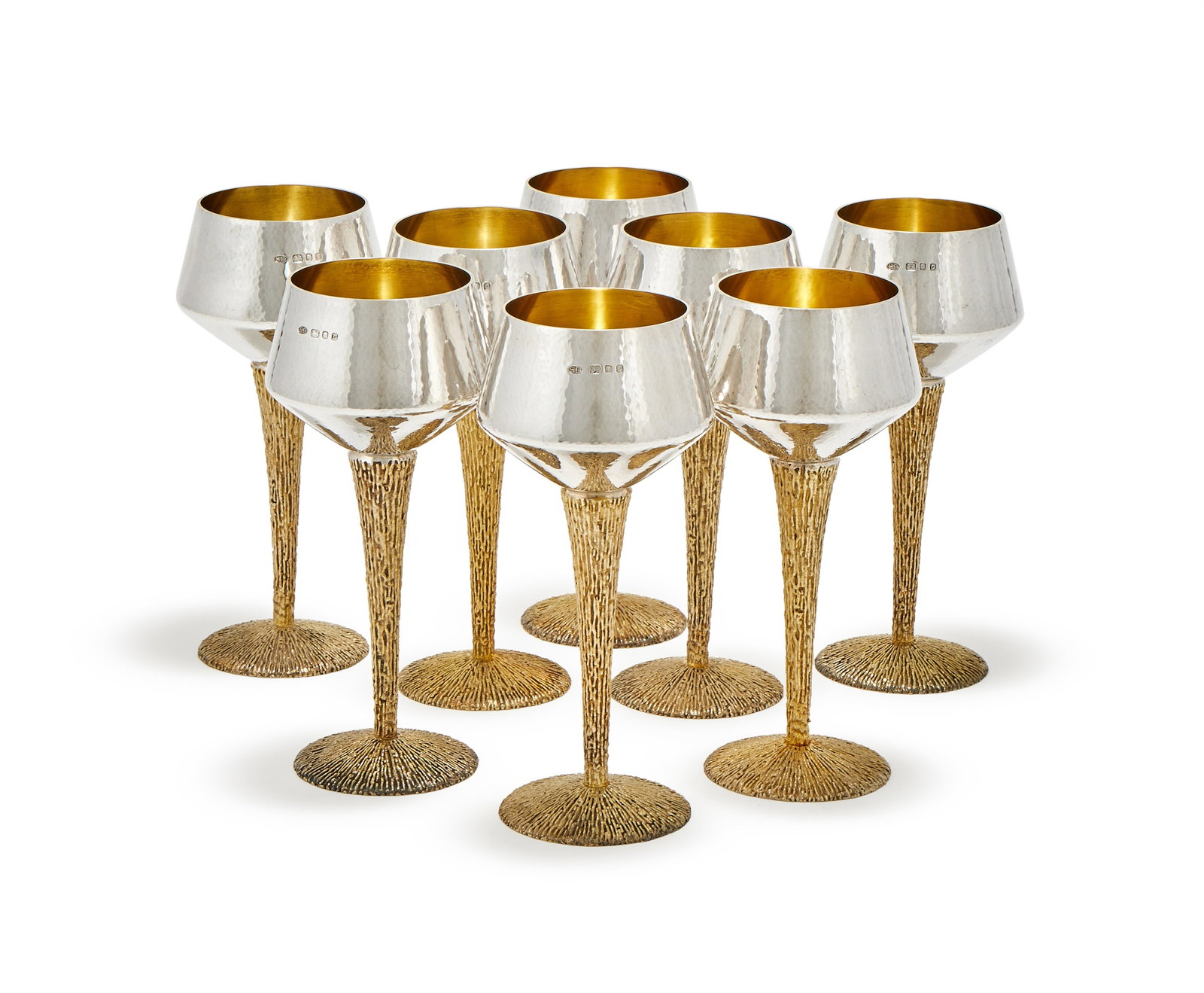 STUART DEVLIN, A SET OF EIGHT SILVER AND SILVER GILT WINE GLASSES, LONDON 1969: STUART DEVLINA SET OF EIGHT SILVER AND SILVER GILT WINE GLASSES, LONDON 1969With hammered bowls, silver gilt textured stems and domed circular bases18.5cm high2370g (76.2 oz)Provenance:A Private Colle