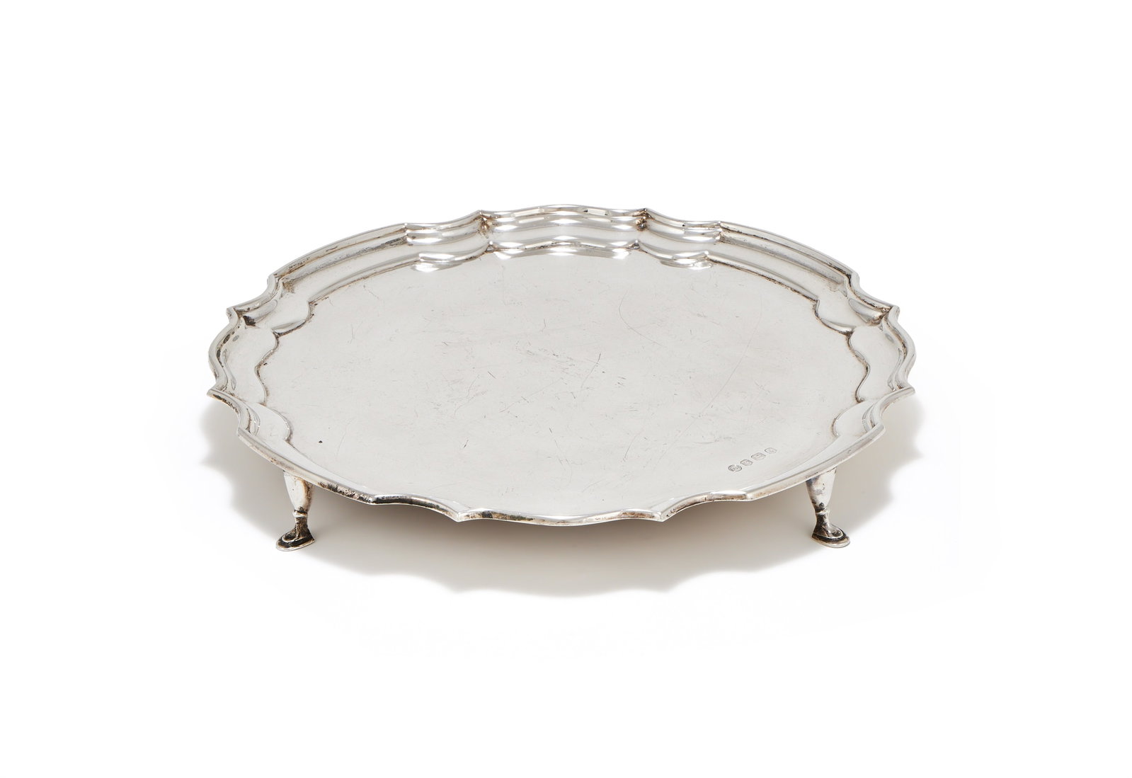 A SILVER SHAPED CIRCULAR SALVER, FRANCIS HOWARD LTD., SHEFFIELD 1979: A SILVER SHAPED CIRCULAR SALVERFRANCIS HOWARD LTD., SHEFFIELD 1979With a raised moulded border and on four stepped pad feet792g (25.45 oz)