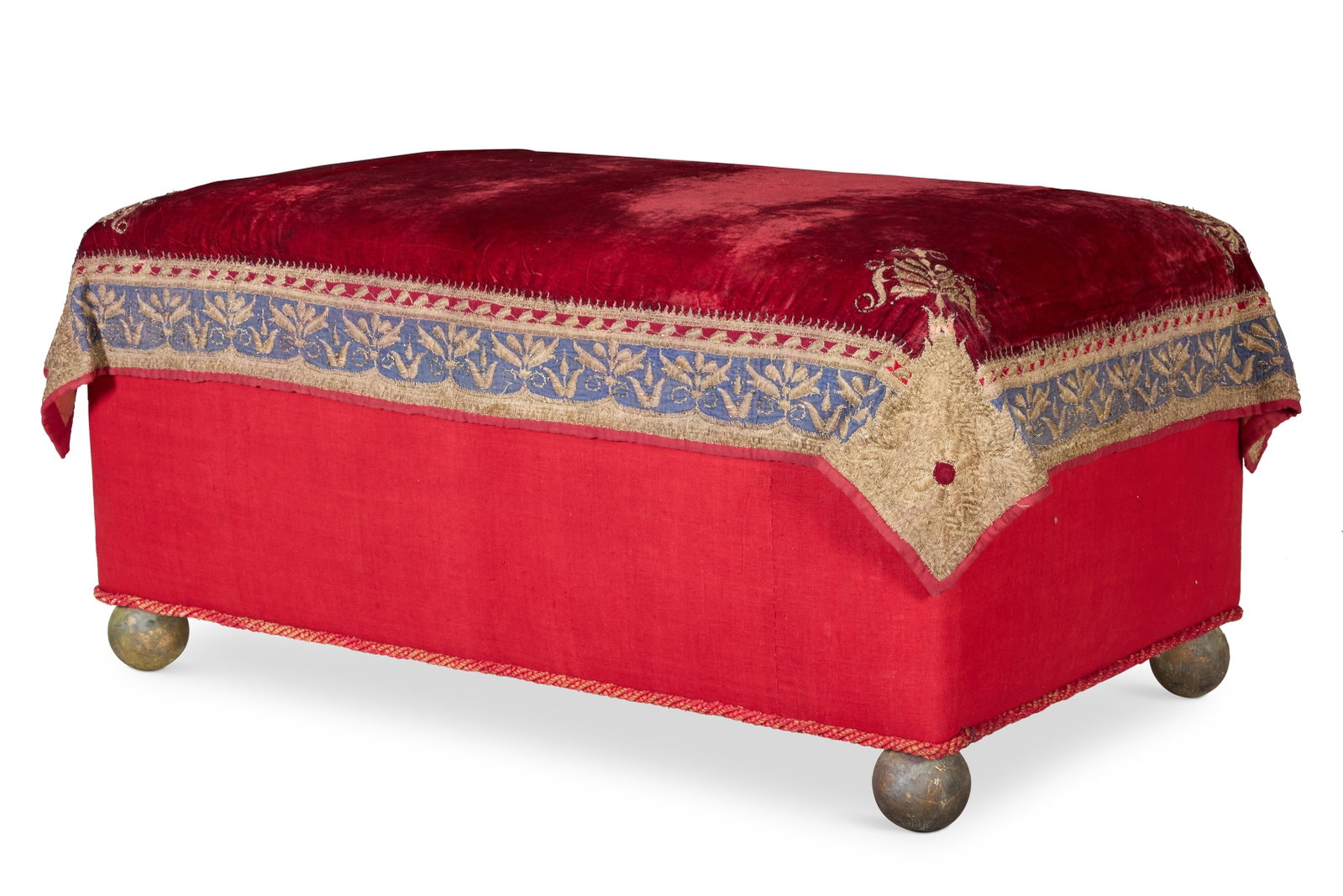 A GOLD THREAD EMBROIDERED RED VELVET COVERED OTTOMAN: A GOLD THREAD EMBROIDERED RED VELVET COVERED OTTOMANMODERN INCORPORATING MUGHAL ZAMIN KALABADU FABRICThe cover with a blue and red ground border60cm high, 125cm wide, 73cm deep