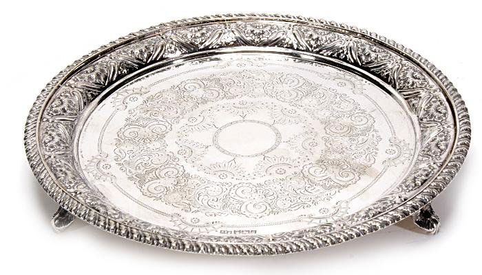 A late Victorian silver circular small salver by R: A late Victorian silver circular small salver by Roberts & Belk, Sheffield 1899, engraved with half florette and scroll bands, the raised border with embossed rocaille and lobing, the rim gadroone