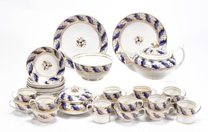 A Derby porcelain part tea service, painted in bl: A Derby porcelain part tea service, painted in blue and gilt with a stiff-leaf band, comprising; a teapot and cover, two saucer dishes, a slop bowl, a sugar box and cover, seven teacups, nine coffee c