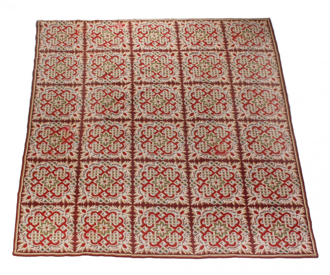 A needlework carpet, probably English, of gridded: A needlework carpet, probably English, of gridded design, each section centred by a patera within an elaborate interwined cartouche border, approximately 299 x 350 Provenance: Property of Mr John Penr