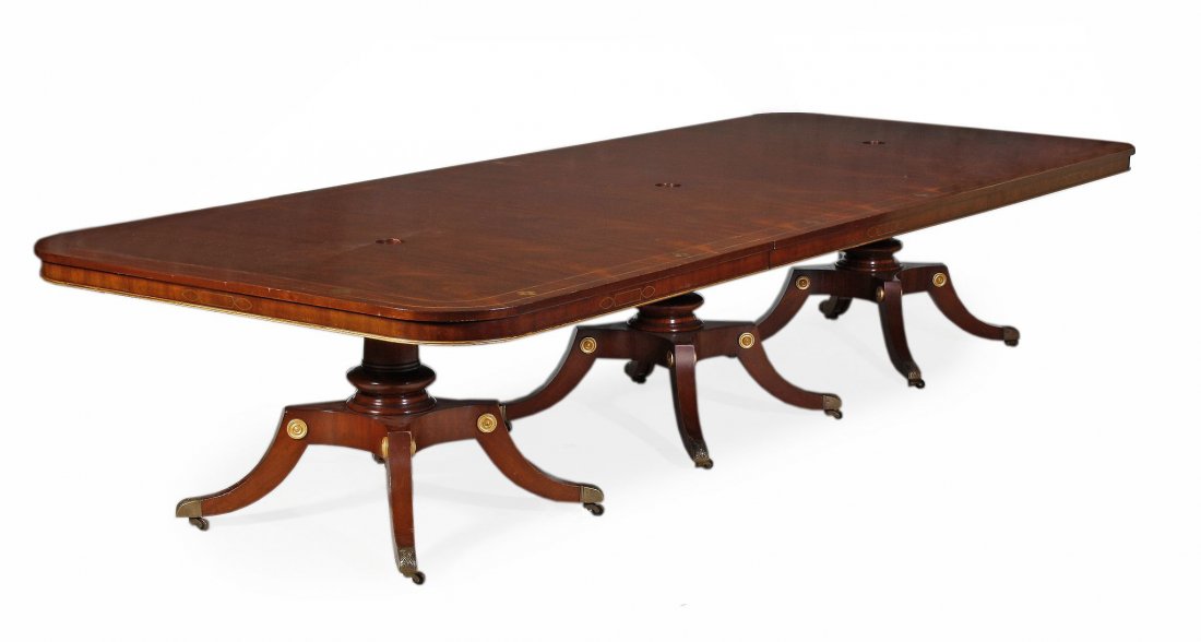A mahogany and simulated brass inlaid triple pedestal: A mahogany and simulated brass inlaid triple pedestal dining table , in Regency style, 20th century, the rectangular top with rounded corners, above a moulded frieze with parcel gilt moulded edge, eac
