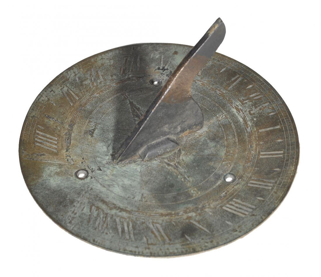 An English brass small garden sundial Unsigned: An English brass small garden sundial Unsigned, second quarter of the 18th century The 6 inch circular plate fitted with angled gnomen set at 51 degrees and centred with an eight-point compass rose wi