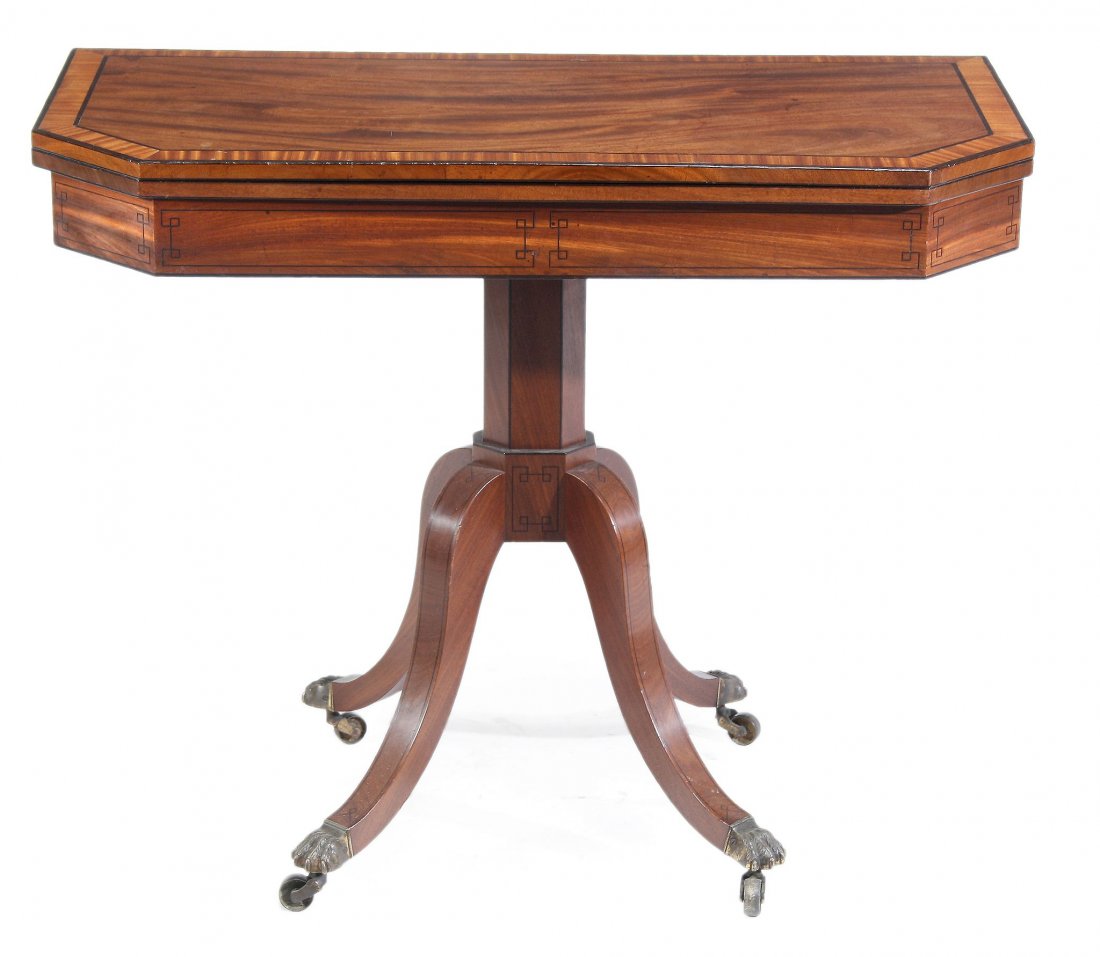 A Regency mahogany and satinwood banded folding tea: A Regency mahogany and satinwood banded folding tea table, circa 1815, the folding rectangular top with canted front corners, above a frieze decorated with ebonised stringing, the octagonal stem on fo