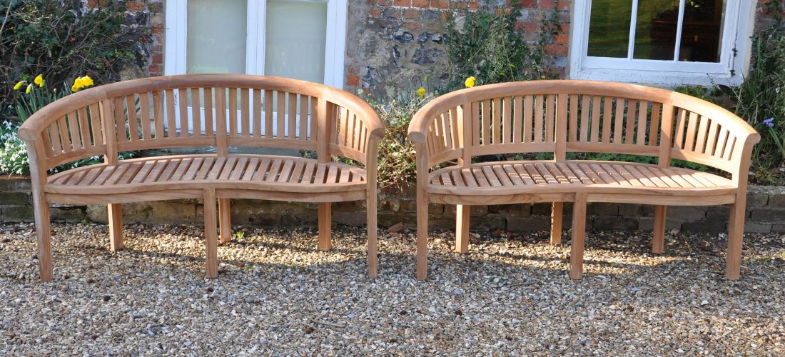 A pair of teak garden benches, of recent manufacture: Additional lot: A pair of teak garden benches, of recent manufacture, each with arched backrest with vertical slats, above a semi-elliptical slatted seat with serpentine front rail, 86cm high, 160cm w