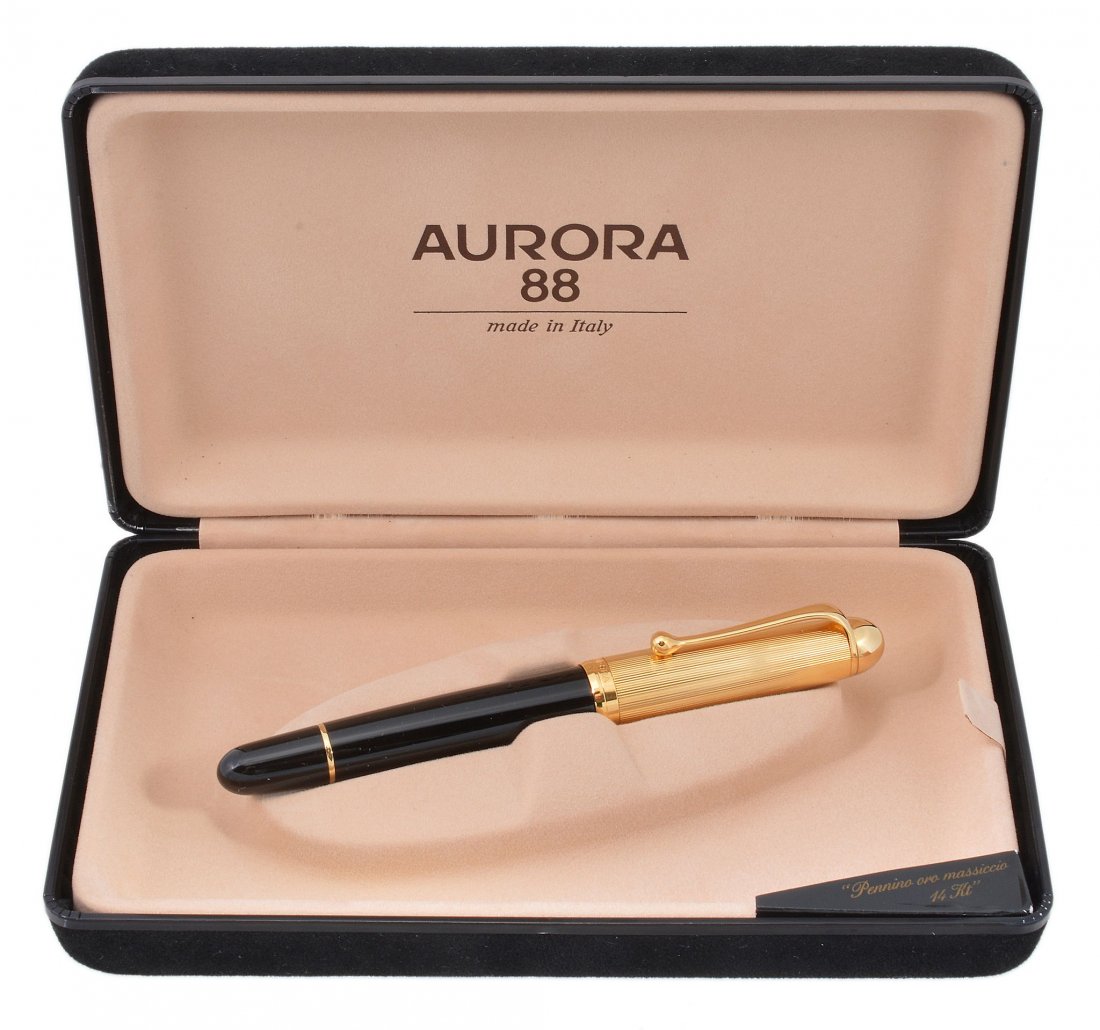 Aurora, a black resin and gold plated fountain pen: Aurora, a black resin and gold plated fountain pen, with a black resin barrel and gold plated reeded cap, the nib stamped K', with a piston filling system, uninked, in a black Aurora box with outer ca
