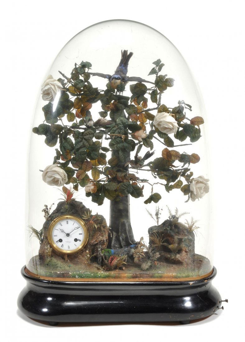 A Victorian singing bird automaton table clock, late: A Victorian singing bird automaton table clock, late 19th century, the four birds tweeting and moving amongst the boughs of a wirework and fabric flower adorned rosebush, the clock within a rocky outc