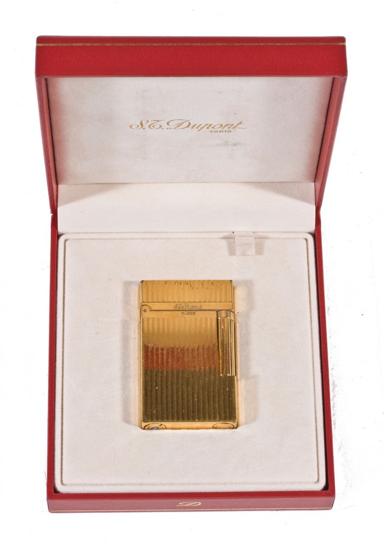 A silver cigar tube, London 2000, with engine turned: A silver cigar tube, London 2000, with engine turned engraving throughout, 12.7cm long; a black leather double cigar tube by S.T.Dupont, 23cm long; an S.T.Dupont lighter, in a fitted case; and a cigar