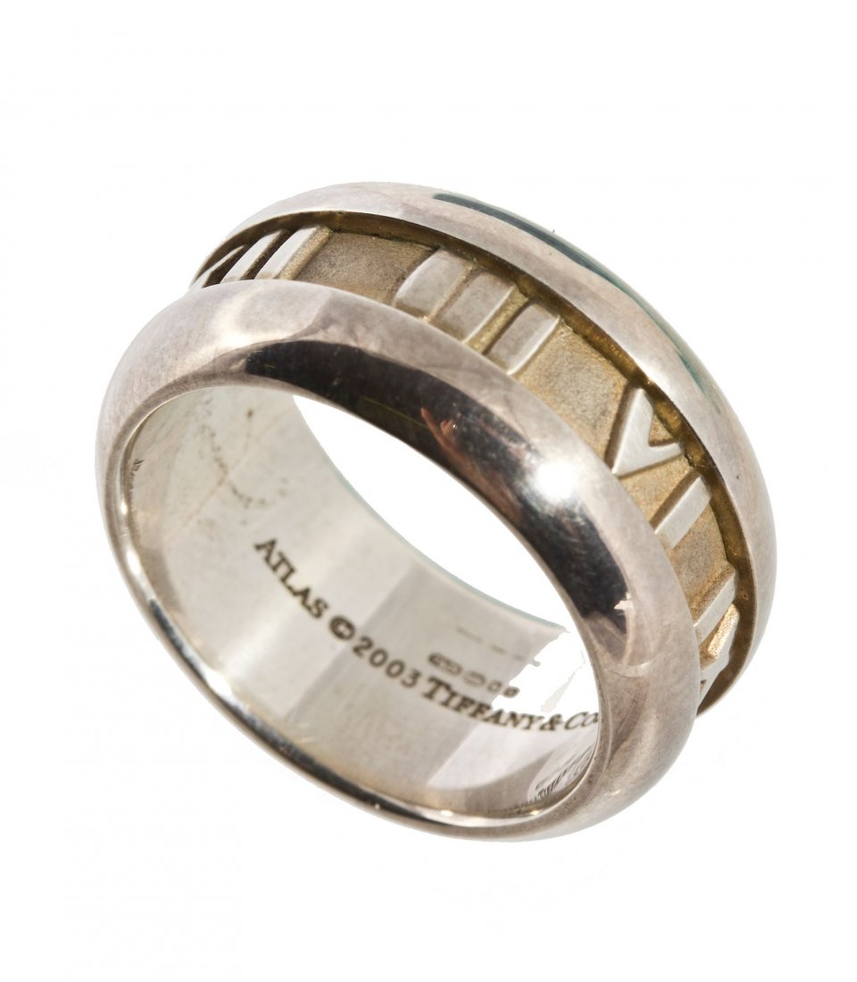 Tiffany & Co., Atlas, a silver ring, with applied Roman: Tiffany & Co., Atlas, a silver ring, with applied Roman numerals to the surround, signed Tiffany & Co., stamped 925, finger size K 1/2, with a Tiffany & Co pouch, box and paperwork, 9.3g (0.29oz)