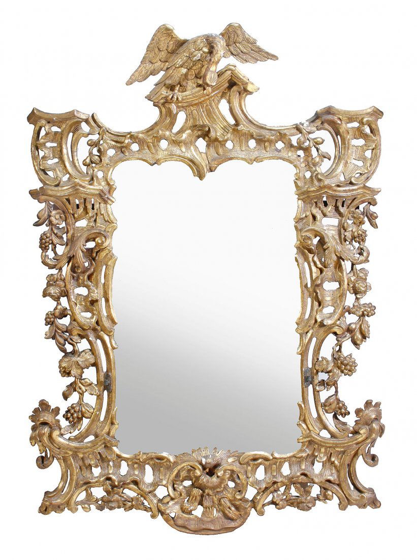 A carved giltwood framed wall mirror in George III: A carved giltwood framed wall mirror in George III style, 19th century, in the manner of Thomas Chippendale, the mirror surmounted by a carved eagle with wings outspread, above an elaborate pierced fr