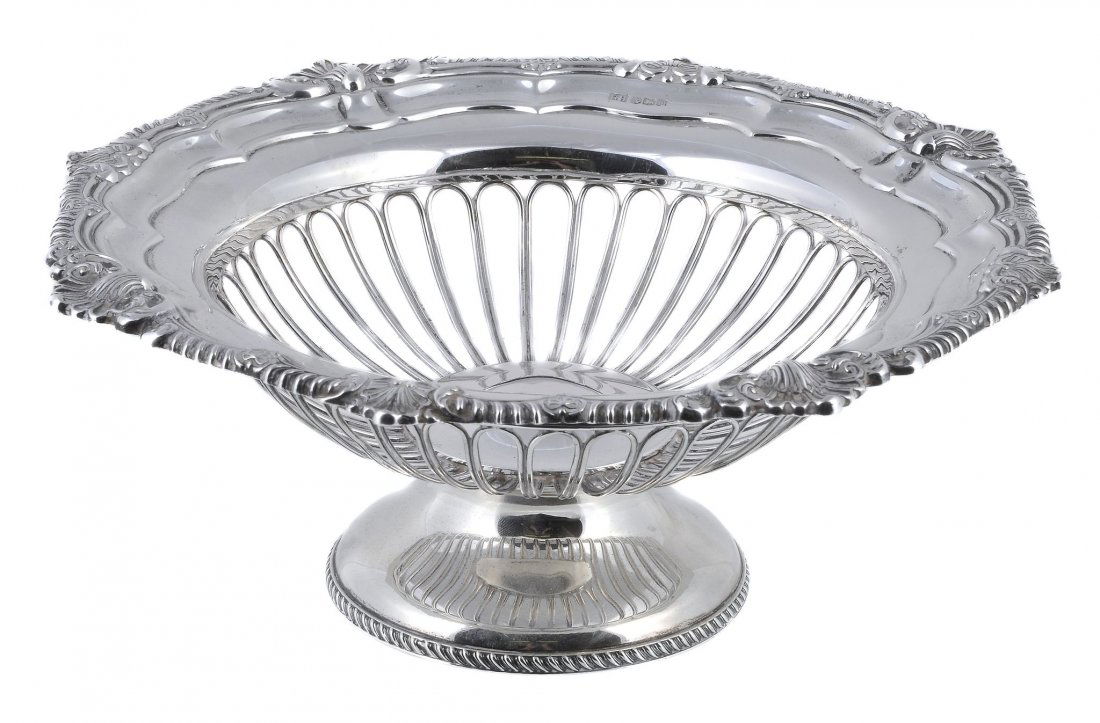 A silver shaped circular pedestal fruit basket by: A silver shaped circular pedestal fruit basket by Harrison Brothers & Howson, Sheffield 1929, with a moulded gadrooned and shell border, a wirework body, on a pedestal circular and gadrooned foot, 28.