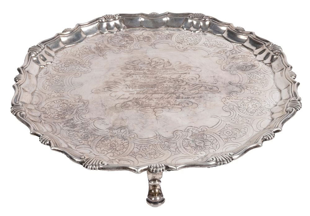 A George II silver shaped circular salver by Robert: A George II silver shaped circular salver by Robert Abercromby, London 1744, engraved with a band of flower filled reserves, a raised border, a moulded rim with shells and on four pad feet, later pres