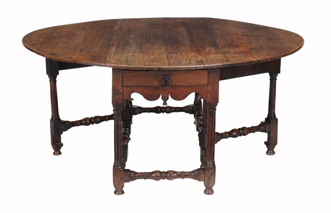 A Charles II oak gateleg table, circa 1680: A Charles II oak gateleg table, circa 1680, the oval drop leaf top above a frieze drawer to one end, with shaped aprons centred by drop pendant, on fluted legs joined by ring turned stretchers, on tur