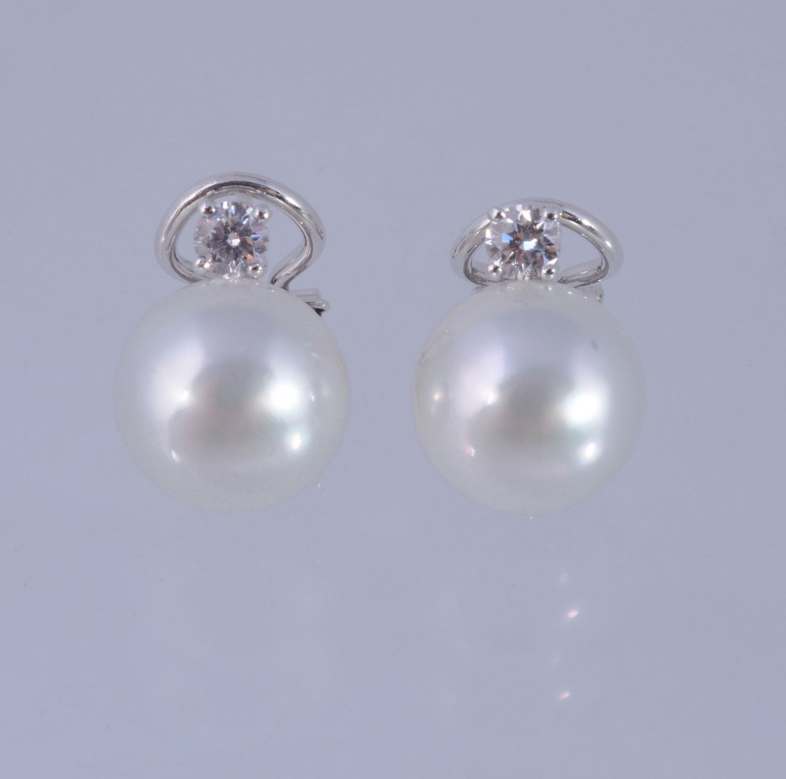 A pair of diamond and South Sea cultured pearl earrings: A pair of diamond and South Sea cultured pearl earrings, the cultured pearls with a brilliant cut diamond surmount, approximately 0.34 carats total, with stud and clip fittings, 1.5cm long