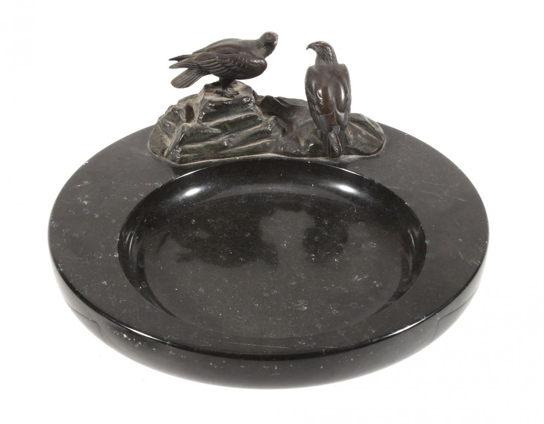 A patinated bronze and black marble vide poche, circa: A patinated bronze and black marble vide poche, circa 1930, the bronze modelled as two eagles on a rocky base, signed in the maquette Hobold , the base circular with a circular well, 25.5cm diameter