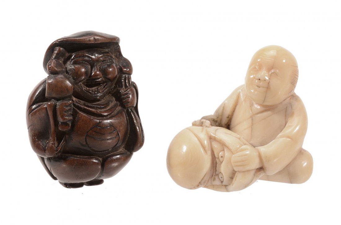 A Wood Netsuke of Daikoku, the portly figure stands: A Wood Netsuke of Daikoku, the portly figure stands with his sack over one shoulder and his mallet in his hand, we wears a broad smile on his face, traces of a scratched signature to the feet, 18th-19