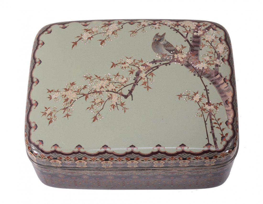 A Japanese Namikawa Cloisonné Enamel Box and Cover: A Japanese Namikawa Cloisonné Enamel Box and Cover, decorated on a celadon ground with a long-eared owl perched on a branch of a cherry tree in blossom, the border and base with a complex multipl