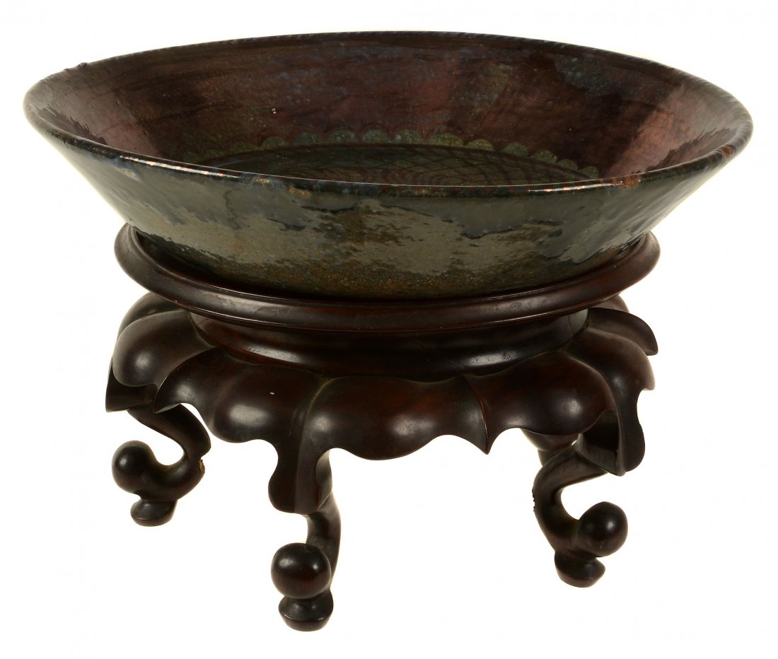 A ruby lustre hard red clay pottery bowl by Alfred: A ruby lustre hard red clay pottery bowl by Alfred Powell, 1920s, painted with a crouching tiger on a trellis ground, impressed M (Millwall Pottery?), silver lustre painted with Powell's monogram and