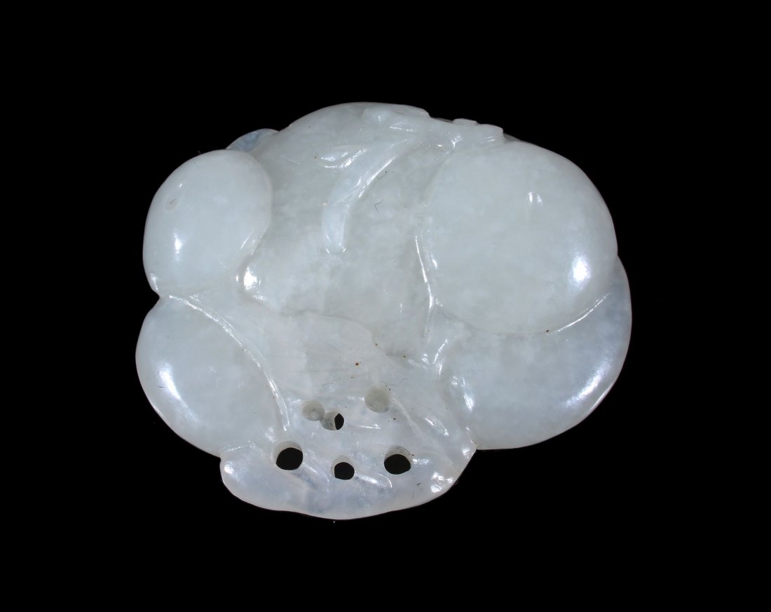 A white jade pendant carved as a group of fruits and: A white jade pendant carved as a group of fruits and fungi, 19th or first half of 20th century, with mutton fat inclusions, 4.5cm wide x 4cm high 十九 /二十世纪 