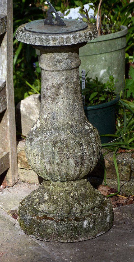 A stone composition and metal mounted garden sundial,: A stone composition and metal mounted garden sundial, 20th century, with gnomon and circular plate above a baluster shaft, 78cm high
