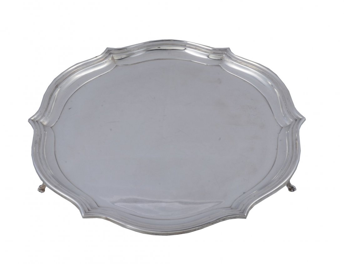A silver shaped circular salver by Roberts & Belk,: A silver shaped circular salver by Roberts & Belk, Sheffield 1933, with a moulded raised rim, on three scroll supports with trefid feet, 35cm (13 3/4in) diameter, 1533g (49.3 oz)