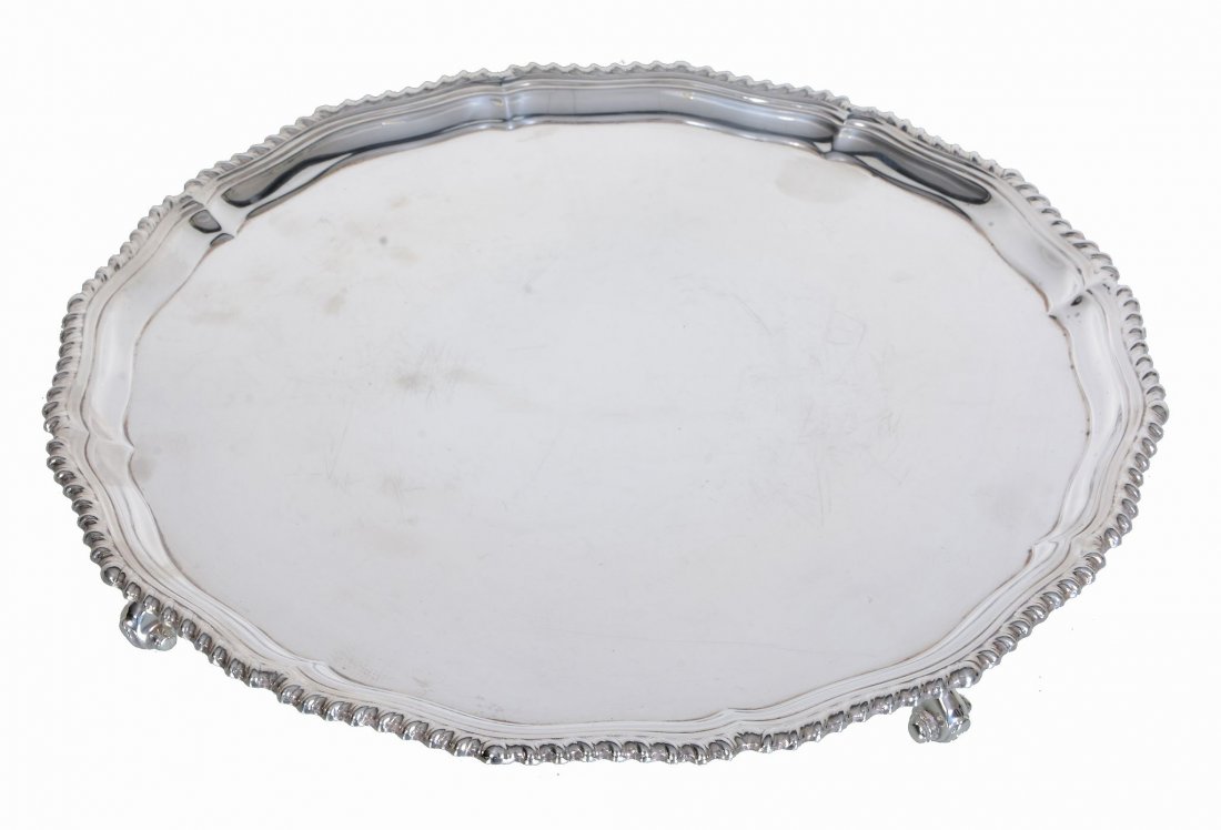 A silver shaped circular salver by Roberts & Belk,: A silver shaped circular salver by Roberts & Belk, Sheffield 1972, with a raised gadrooned rim and on four scroll feet, 31 (12 1/4in) diameter, 926g (29.75 oz)