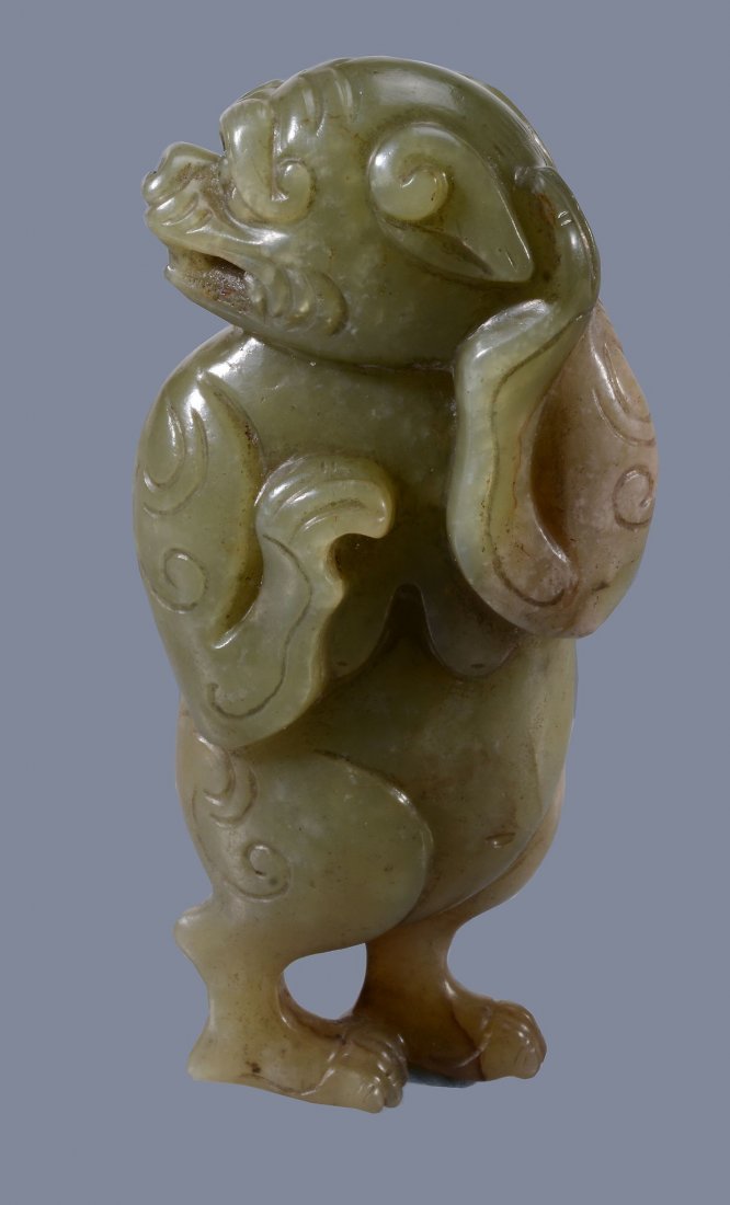 A Chinese yellow and russet jade model of a Lion,: A Chinese yellow and russet jade model of a Lion, standing on two legs, the head turned to one side, 8.5cm high x 4.3cm wide x 2cm deep -1黄玉立狮