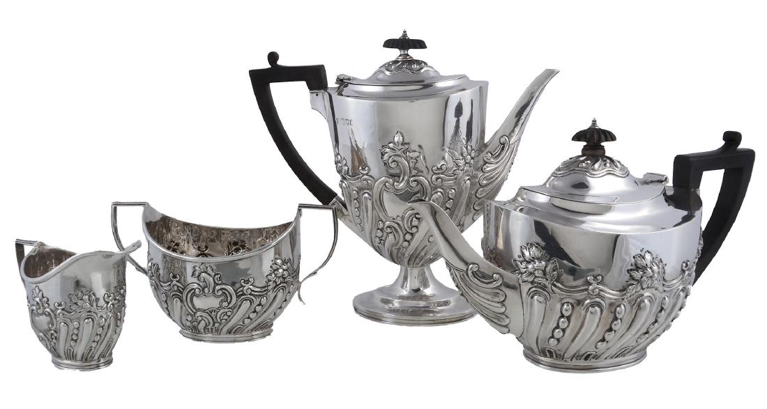 A matched Edwardian silver four piece oval tea and: A matched Edwardian silver four piece oval tea and coffee service by Charles Stuart Harris, London 1903 (the coffee pot 1901), the tea and coffee pots with ebonised lobed oval finials and harp handles