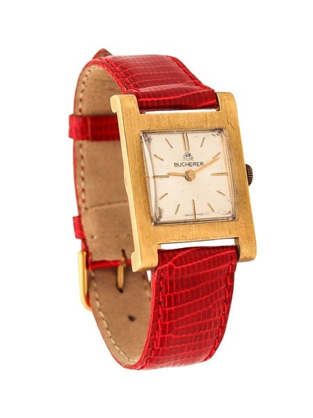 BUCHERER Swiss Wristwatch In 18Kt Yellow Gold With Red Lizard Leather Strap: A wristwatch designed by Bucherer.This is a classic manual wingding wristwatch, created in Switzerland by the company of Bucherer. The case has been designed in the shape of a H and was crafted in sol