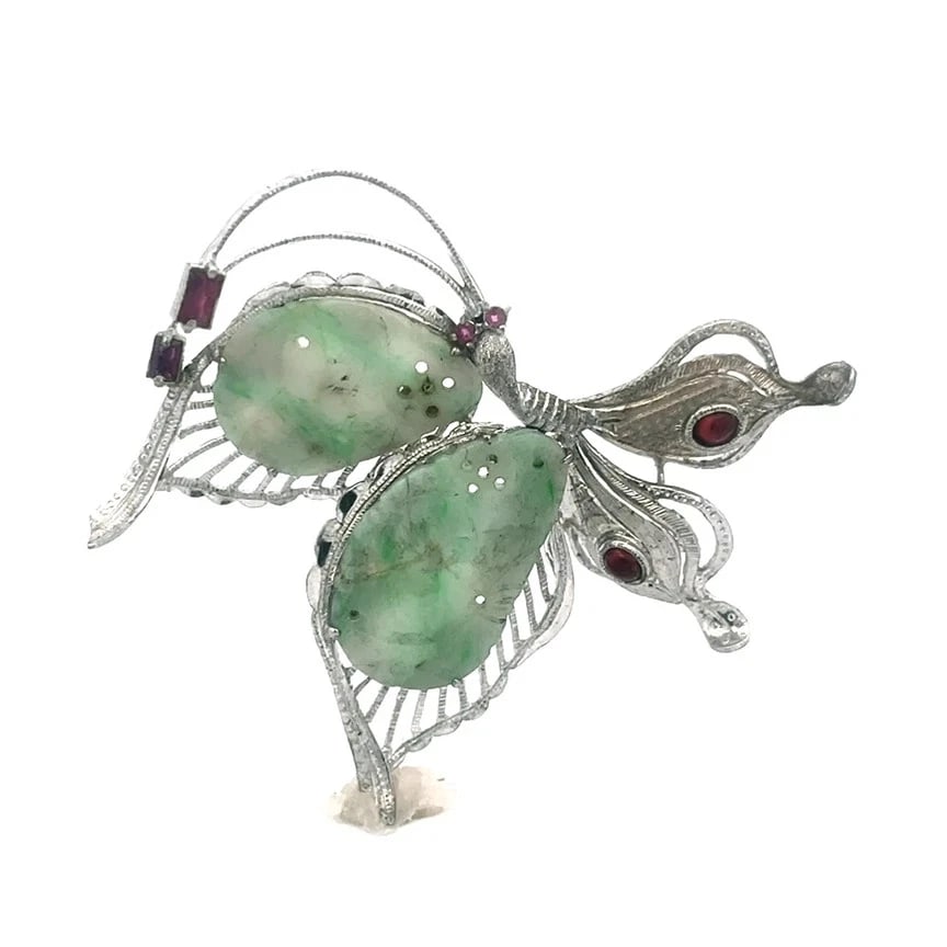 Jade Sterling Silver Butterfly Brooch Vintage Open Style: This product is a vintage sterling silver butterfly brooch featuring natural green jade with red and white stones. The brooch is adorned with open silver milgrain design and has a prong setting style,