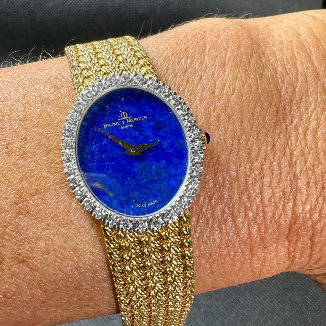 1970’s BAUME ET MERCIER 18K Yellow Gold Lapis Lazuli Watch: 1970’s BAUME ET MERCIER 18K Yellow Gold Lapis Lazuli WatchWeighing 53.7 gramsSet with an original Lapis Lazuli dialAlong with an original diamond bezel set with 32 Diamonds weighing app. 1.00