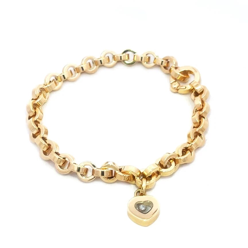 Chopard Happy Diamond Gold Bracelet 18k Yellow Heart Charm Style: This is a beautiful Chopard bracelet from the Happy Diamond Collection, it is a luxurious piece of fine jewelry featuring a lovely dangling heart charm with a floating diamond in the heart shape glass