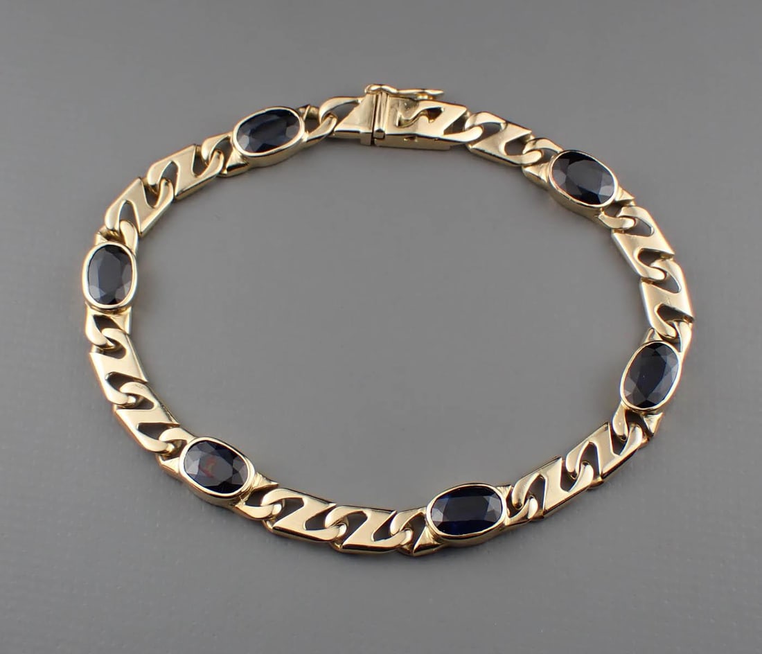 SAPPHIRE & 18K GOLD BRACELET: SAPPHIRE & 18K GOLD BRACELET:6-1/2 inch length yellow gold mariner link chain with six bezel set oval-cut blue sapphires weighing approximately 5.72 cttw. The bracelet weighs 11.6 grams and is stamped