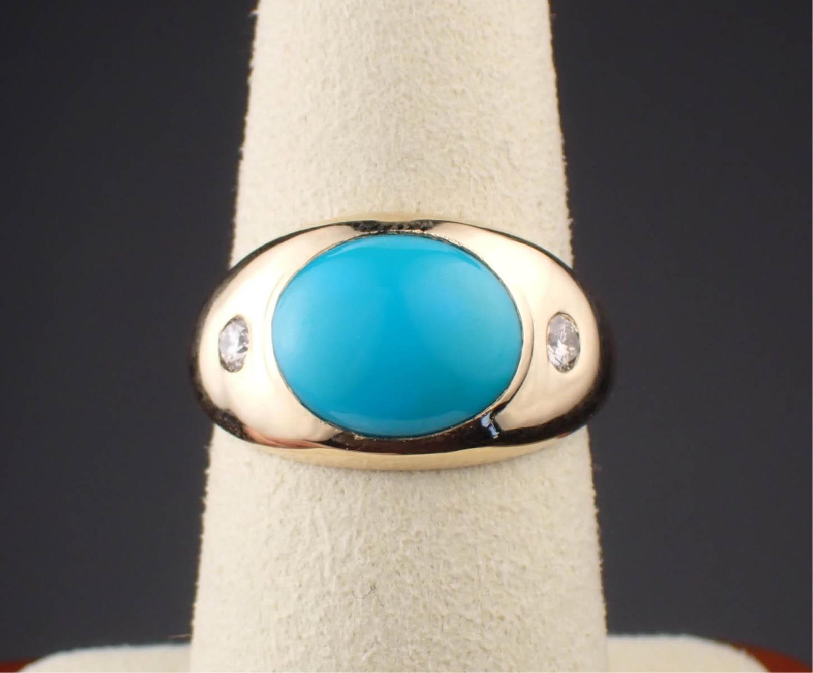 TURQUOISE, DIAMOND & 14K YELLOW GOLD RING: TURQUOISE, DIAMOND & 14K YELLOW GOLD RING:set with a pair of round-cut diamonds weighing 0.18 cttw, and centered with a 3.45 cts. oval turquoise cabochon. The ring weighs 3.4 grams and is stamped "14K