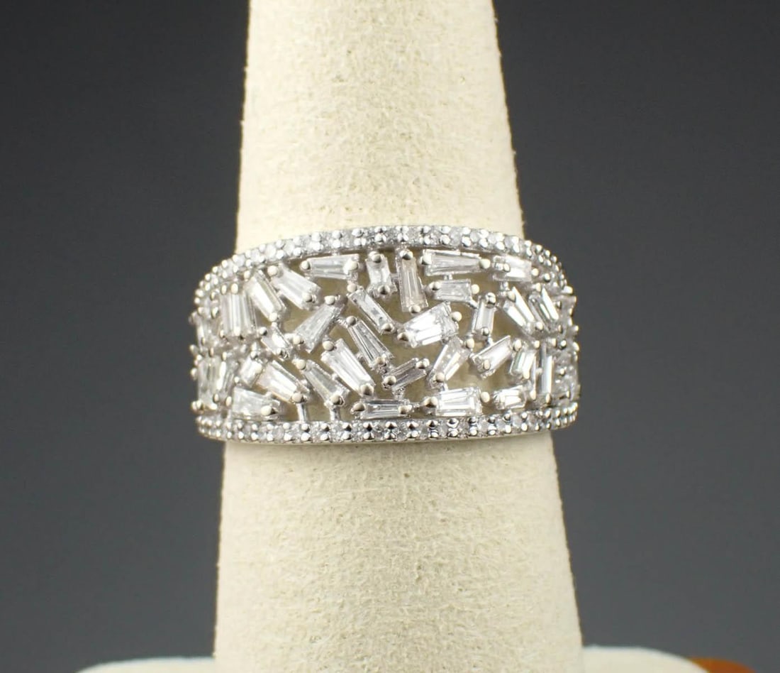 DIAMOND & 14K WHITE GOLD RING: DIAMOND & 14K WHITE GOLD RING:featuring an intricate openwork design set with a mix of straight baguette and tapered baguette-cut diamonds accented with a row of round-cut diamonds on each side. Total